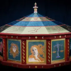 A large wooden carousel with painted designs on it.